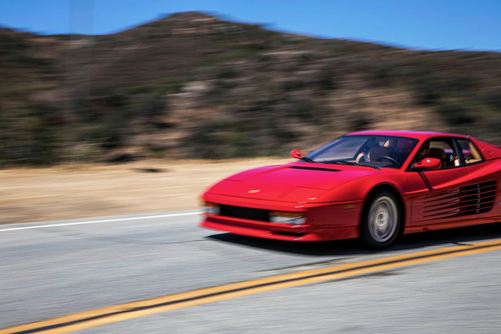 A classic sports car glides along a winding coastal road, showcasing stunning landscapes of dramatic cliffs and the sparkling ocean below. This picturesque journey offers a self drive tour experience, allowing drivers to explore at their own pace while taking in the timeless beauty of the rugged coastline.